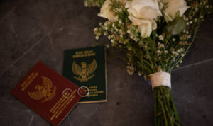 a pair of wedding books and a bunch of flowers on the wedding table