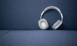 White and gray wireless headphones on a blue sofa, ready to deliver powerful